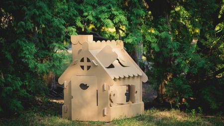 Toy house made of corrugated cardboard in the city park on the grass. The concept of eco-estateの写真素材