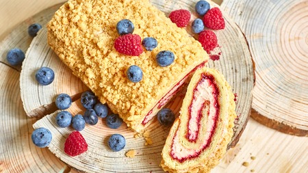 bright colorful cake roll on wood with berry. Shallow dofの写真素材