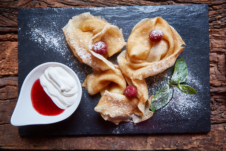 Crepes with raspberries with copy space on black backgroundの写真素材