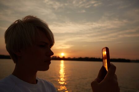 close-up portrait of a beautiful young blonde woman makes selfyの写真素材