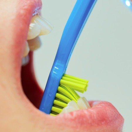 Dentist showing a woman how to brush her teeth. Closeup. Shallow dofの写真素材
