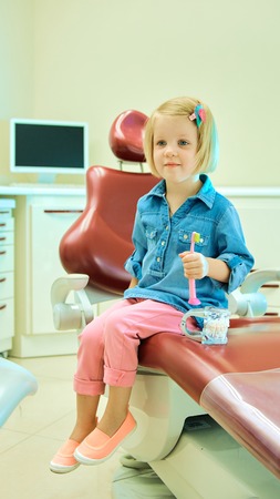 Little blond girl sitting in the dentists officeの写真素材