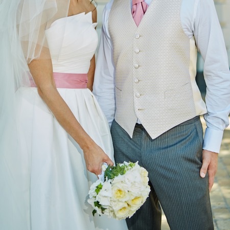 Elegant bride and groom posing together outdoors on a wedding dayの写真素材