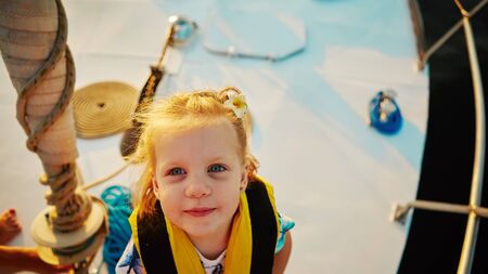 Little girl enjoying ride on yacht at sunsetの写真素材