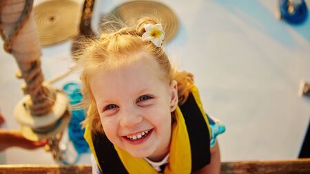 Little girl enjoying ride on yacht at sunsetの写真素材