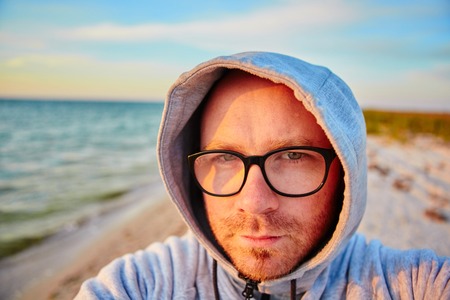 Handsome man with glasses making selfie and smilingの写真素材