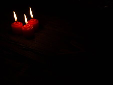 three burning candles of advent on black backgroundの写真素材