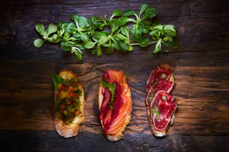 Various bruschettas on wooden table, top viewの写真素材