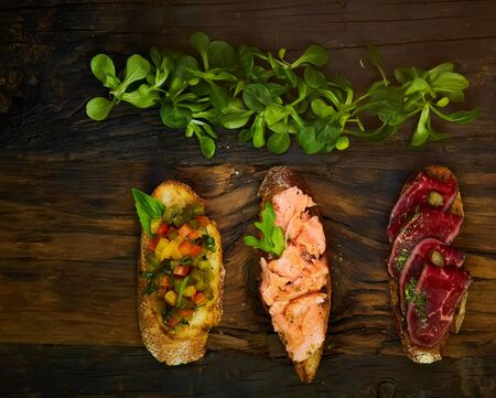 Various bruschettas on wooden table, top viewの写真素材
