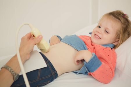 girl getting ultrasound of a stomach from doctor at hospitalの写真素材