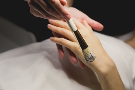 Close up of hands applying cream over table. SPAの写真素材