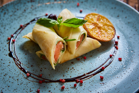 Crepes with smoked salmon on a blue plate for holidayの写真素材