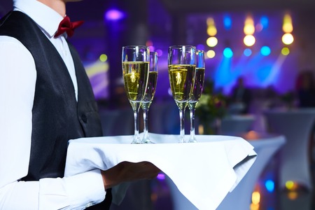 Waiter serving champagne on a tray at partyの写真素材
