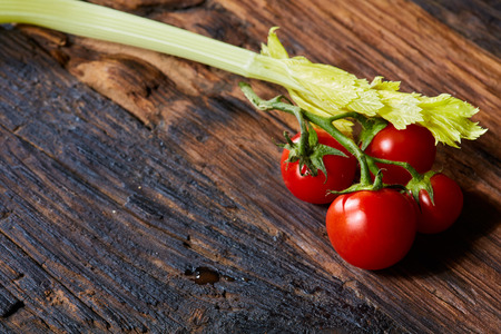 Fresh Raw Celery and Tomatoes Vegetable on Brown Wooden background.の写真素材