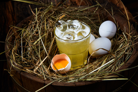 whiskey sour with chicken eggs on hayの写真素材