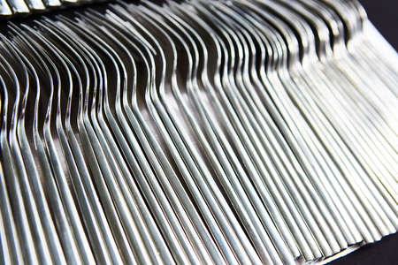 close up of a pile of fork on a tray prepare for event or party. selective focus in warm light room of restaurantの写真素材