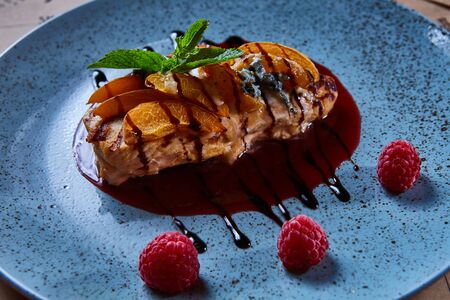 Meat grilled turkey in sauce with dried apricots decorated with raspberryの写真素材