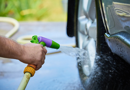 People cleaning car using high pressure water.