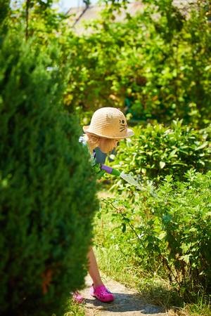 Little girl playing with water in the gardenの写真素材