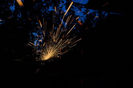 Worker cutting metal with grinder. Sparks while grinding iron.