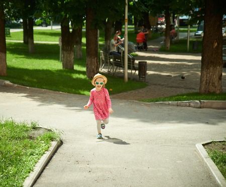 Happy cute little girl running in the park. Happinessの写真素材