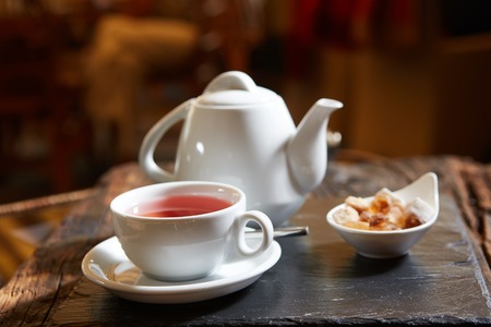 white teapot with tea Cup, saucer and teaspoon.