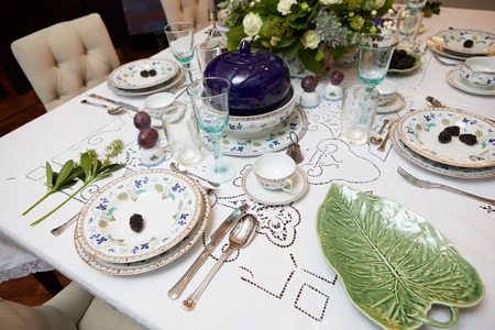 Decorated table ready for dinner. Beautifully decorated table set with flowers, candles, plates and serviettes for wedding or another event in the restaurant.の写真素材