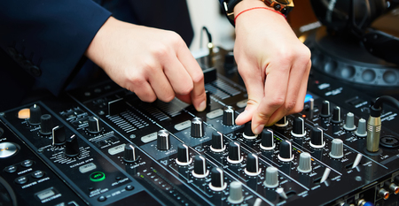 Dj mixes the track in the nightclub at party. Shallow dof