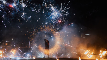Artists juggling with burning poi's at fire performance. Long exposure causing painting with light.