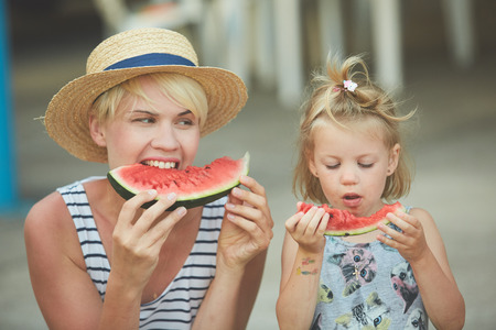 Mother And Daughter Enjoying Slices Of WaterMelon. Film camera styleの写真素材