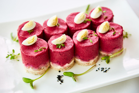 layered salad with herring, beets, carrots, onions, potatoes and eggs close-up on a plate. horizontal.の写真素材