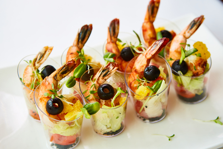 Shrimp, avocado, tomato, salmon cocktail salad served in a glass.の写真素材