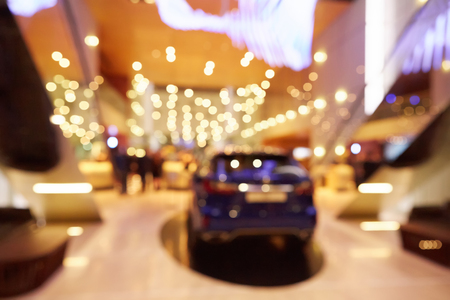 Blurred, defocused background of public event exhibition hall showing cars and automobilesの写真素材