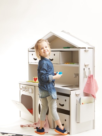 toddler girl playing with toy kitchen at homeの写真素材