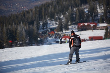 Man snowboarder rides on the slope. ski resort. Space for textの写真素材