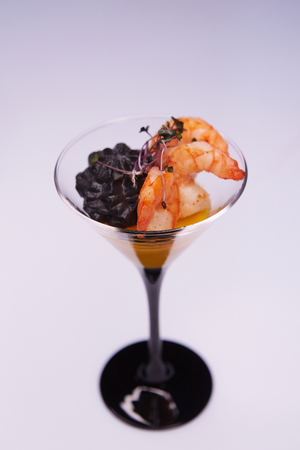 Appetizer in a glass. Shrimp with vegetable puree with cuttlefish ink. Healthy food. Top viewの写真素材
