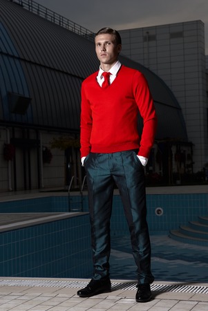 Portrait of an attractive young businessman in urban background wearing red jacket and red tie. Looking to the camera. Classic styleの写真素材