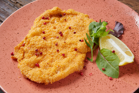 Chicken schnitzel on plate over wooden background, Top viewの写真素材