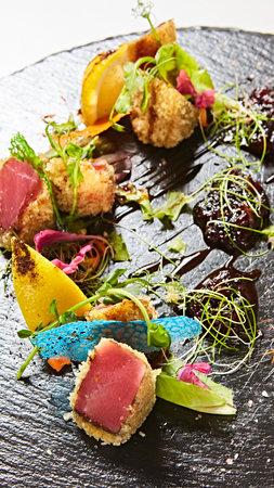 Close up of rare seared Ahi tuna slices with fresh vegetable salad on a plate.