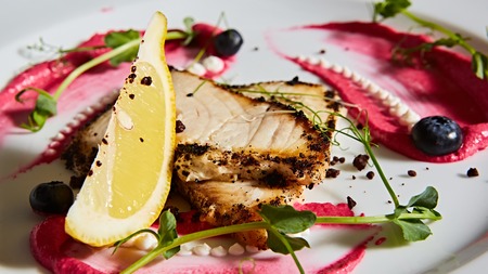 White fish with lemon on white plate, selective focus