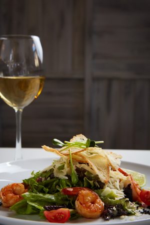 Fresh caesar salad on white bowl with parmesan cheese and shrimps.の写真素材