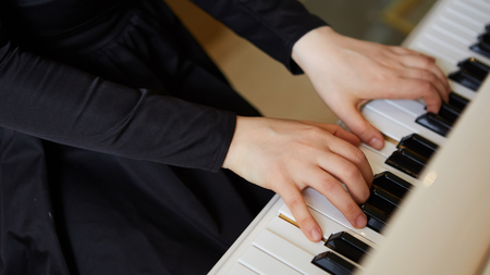Womans hands on the keyboard of the piano closeupの写真素材