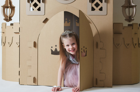 Beautiful little girl in princess dress playing with her toy castle.の写真素材
