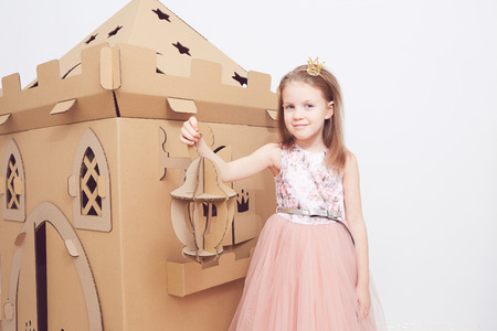 Little princess in crown play with her cardboard castle. True emotion of happiness of the child.の写真素材