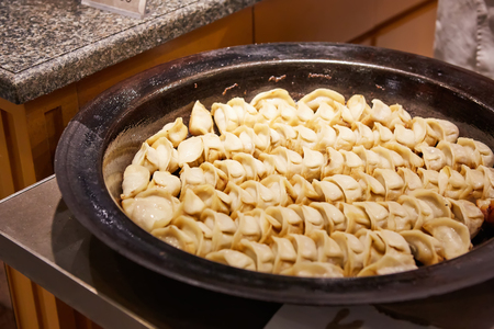 big frying pan with sheng jian bao-traditional chinese pan fried dumplings with minced pork shrimp and vegetables in Shanghai China, Cantonese food,pan-friedの写真素材