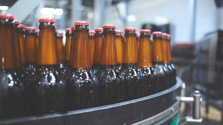 Beer bottles on the conveyor belt. Shallow dof. Selective focus.の写真素材