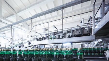 Plastic bottles for beer or carbonated beverage moving on conveyor. Shallow DOF. Selective focus.