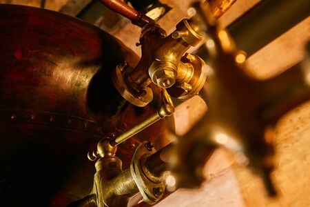Detalis of medieval traditional distiller cube made from copper production of alcohol, cognac, whiskey. Fragment of copper old distiller for alcohol production. Ancient traditional food technologies for alcohol. Shallow dofの写真素材