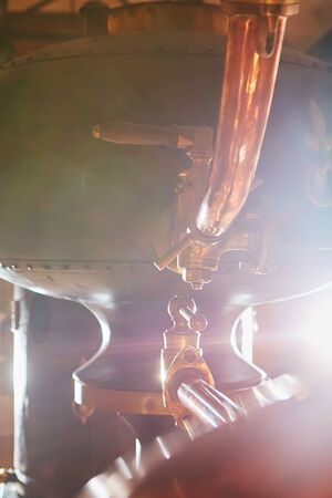 Detalis of medieval traditional distiller cube made from copper production of alcohol, cognac, whiskey. Fragment of copper old distiller for alcohol production. Ancient traditional food technologies for alcohol. Shallow dofの写真素材