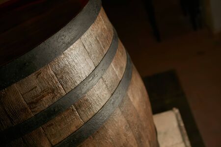 wooden barrel on a dark background, in a workshop, in an old room. production of barrels for cognac...